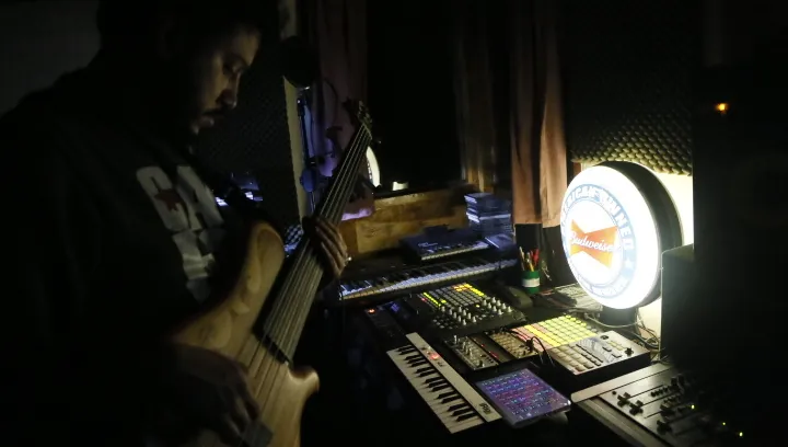 Horacio recording bass in front of synths and controllers